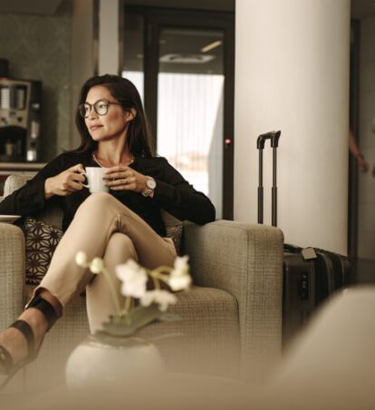 a woman drinking coffee in a lobby