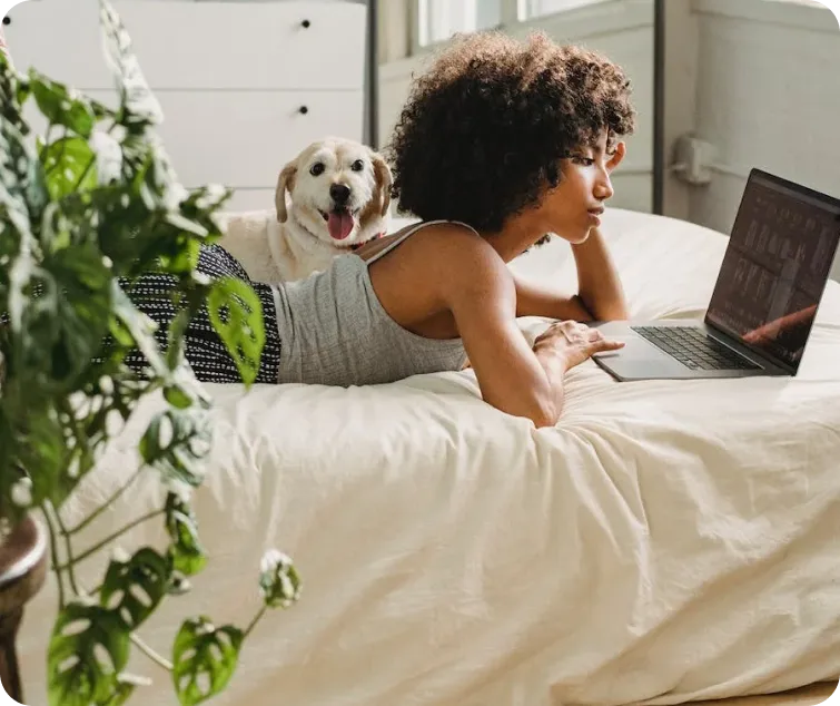 woman laying on bed using a computer