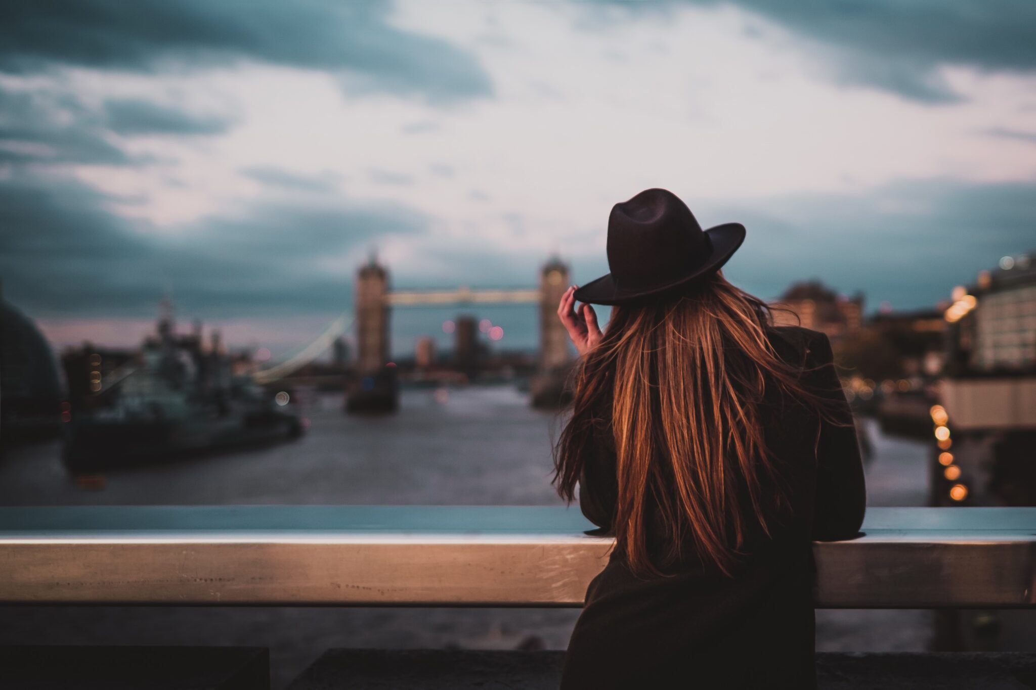 person on a bridge looking out at the city