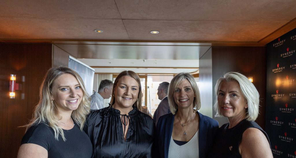 Four women smiling for a photo.
