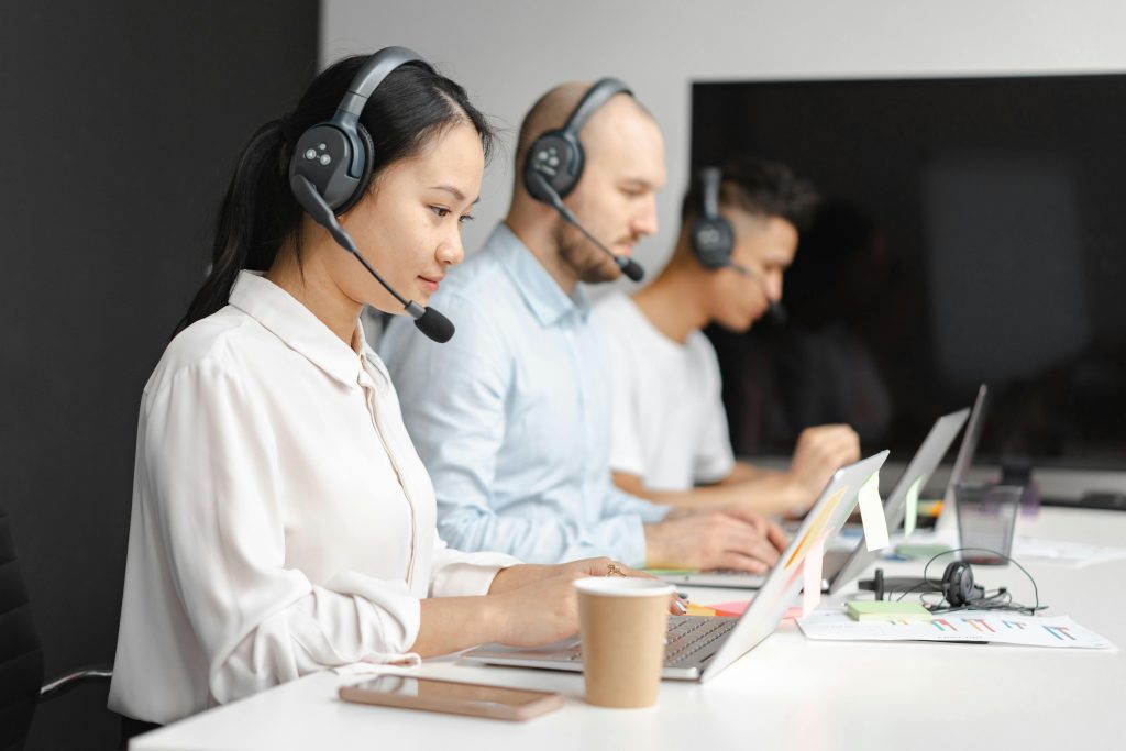 Three call center workers on their computers.