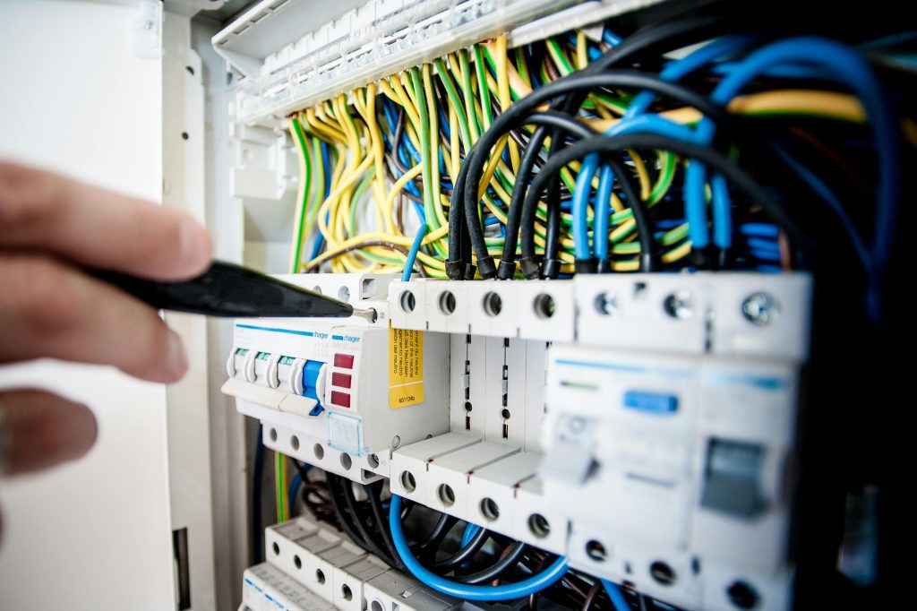 Electrician Fixing an Opened Switchboard.
