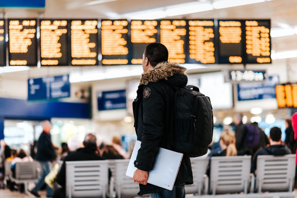Man walking through the airport with a computer in hand.