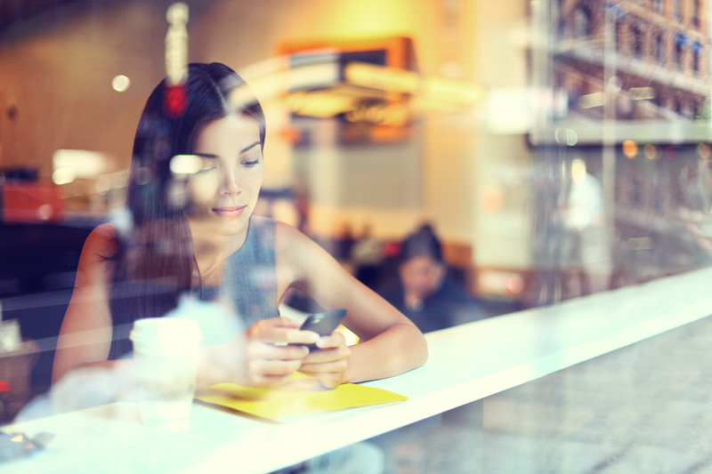 Woman looking at her phone in a coffee shop.