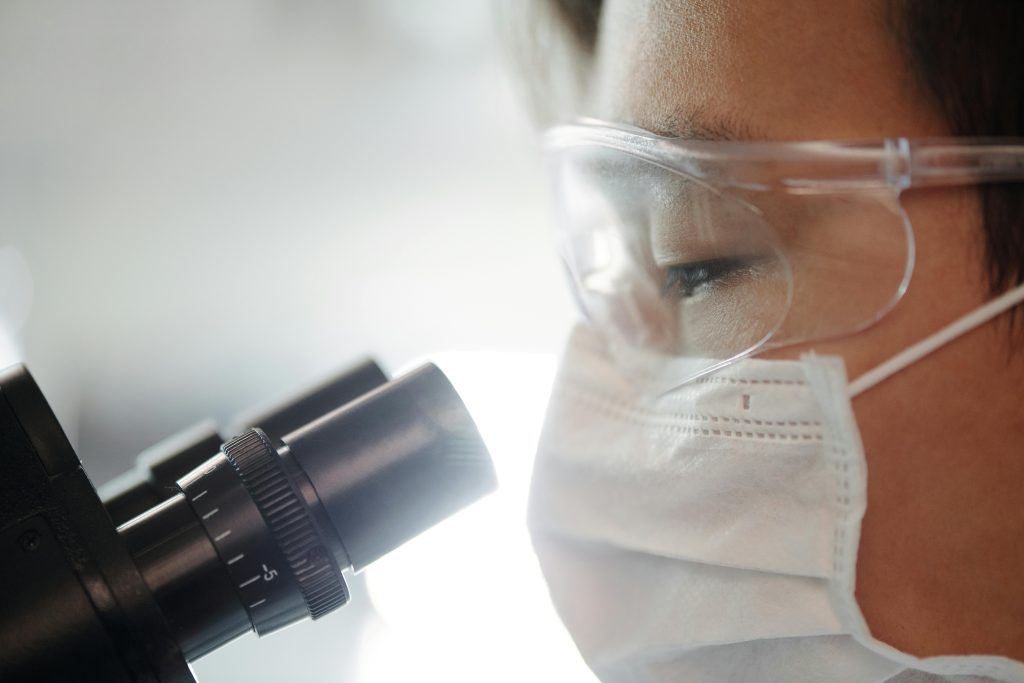 Scientist Looking Through A Microscope