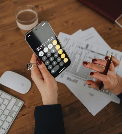 A person using a calculator on their smartphone.