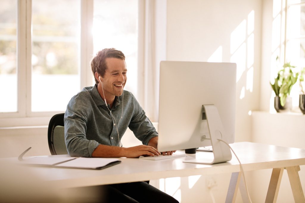 Happy employee working on his computer.